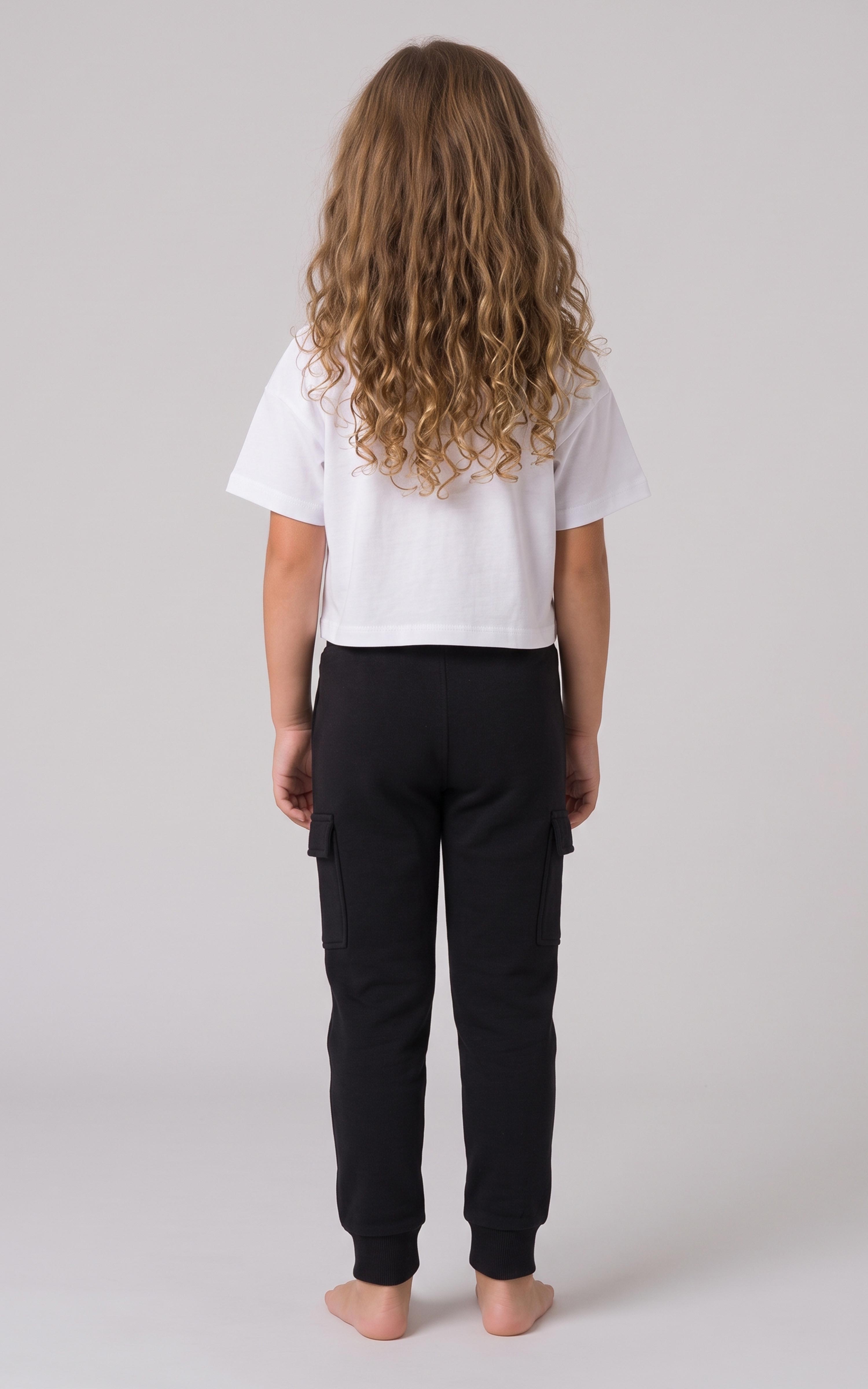 Back view of a girl wearing black tapered joggers with a soft fleece finish and elastic cuffs.