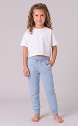 Girl modeling light blue tapered joggers with a drawstring waist and side pockets.