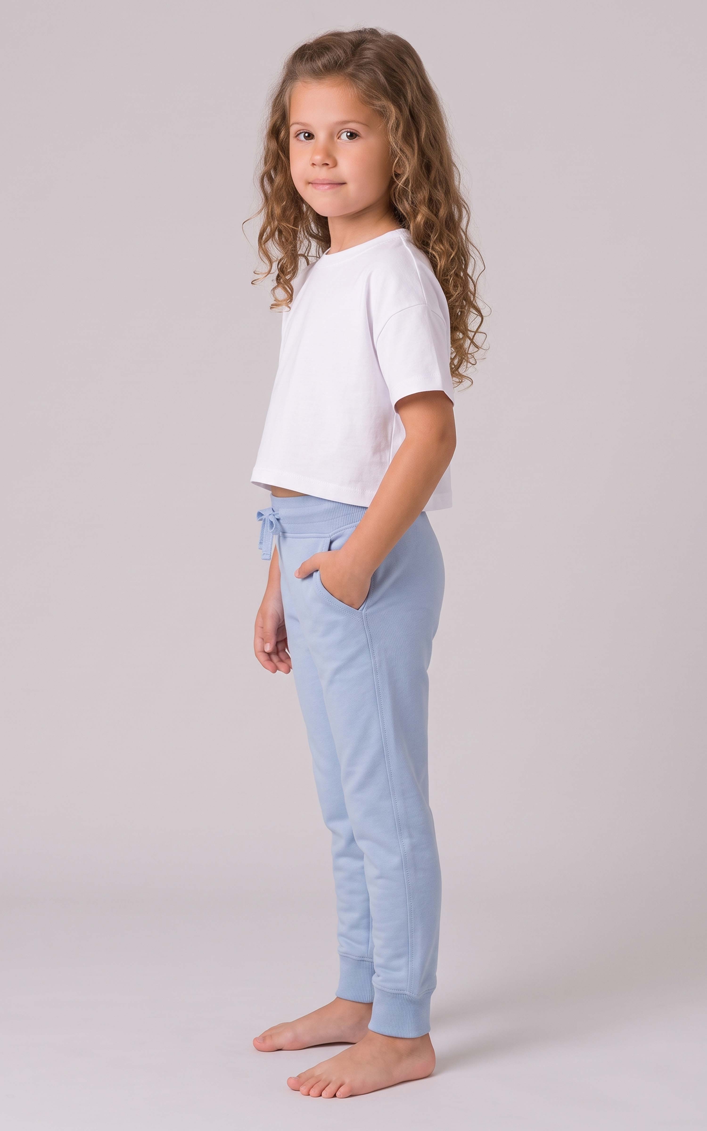 Girl modeling light blue tapered joggers with an elastic waistband, side pockets, and cuffed ankles.