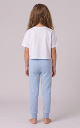 Back view of a girl wearing light blue tapered joggers with an elastic waistband and cuffed ankles.