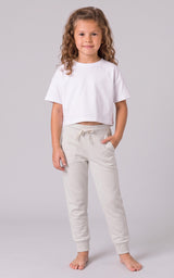Girl wearing light gray tapered joggers with a drawstring waist and side pockets.