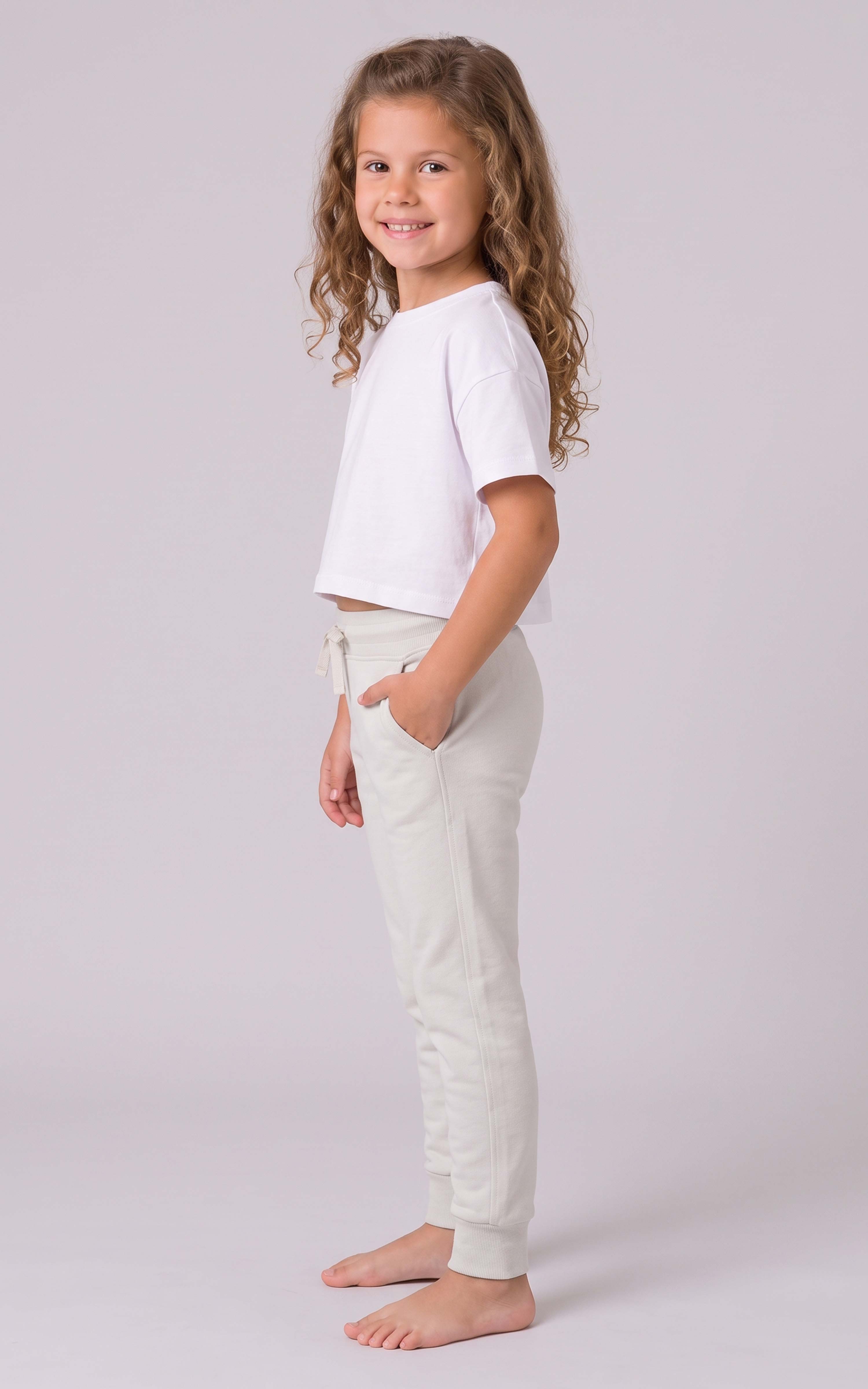 Girl wearing light gray tapered joggers with a drawstring waist and side pockets, paired with a white cropped top.