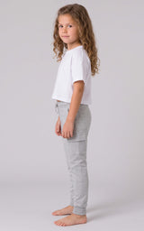 Girl wearing light gray tapered joggers with a soft knit finish, elastic cuffs, and a relaxed fit.