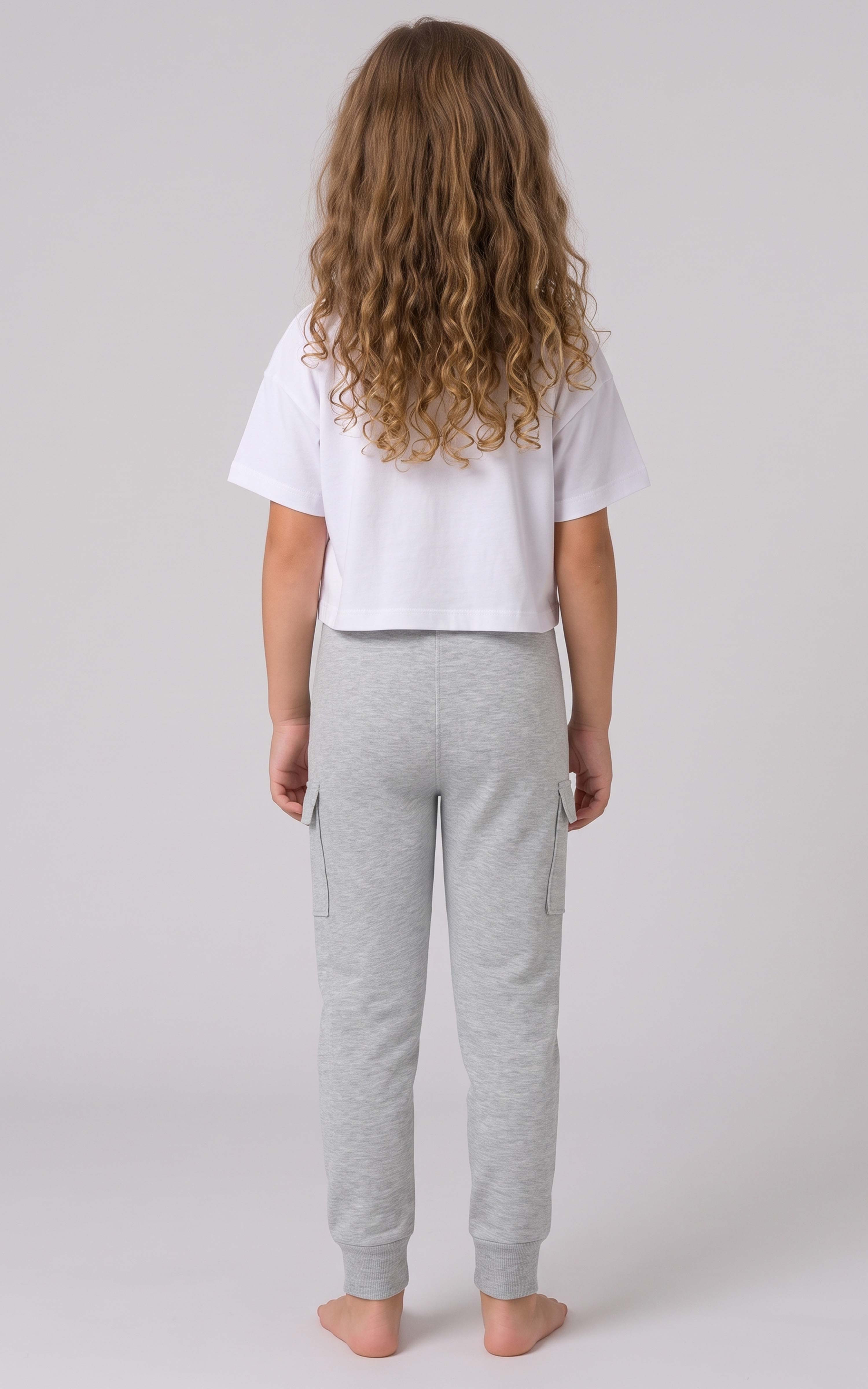 Back view of a girl wearing light gray tapered joggers with an elastic waistband and cuffed ankles.