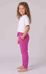 Girl wearing bright pink tapered joggers with a drawstring waist and side pockets, paired with a white T-shirt.