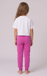 Back view of a girl wearing bright pink tapered joggers with an elastic waistband and gathered ankle cuffs.
