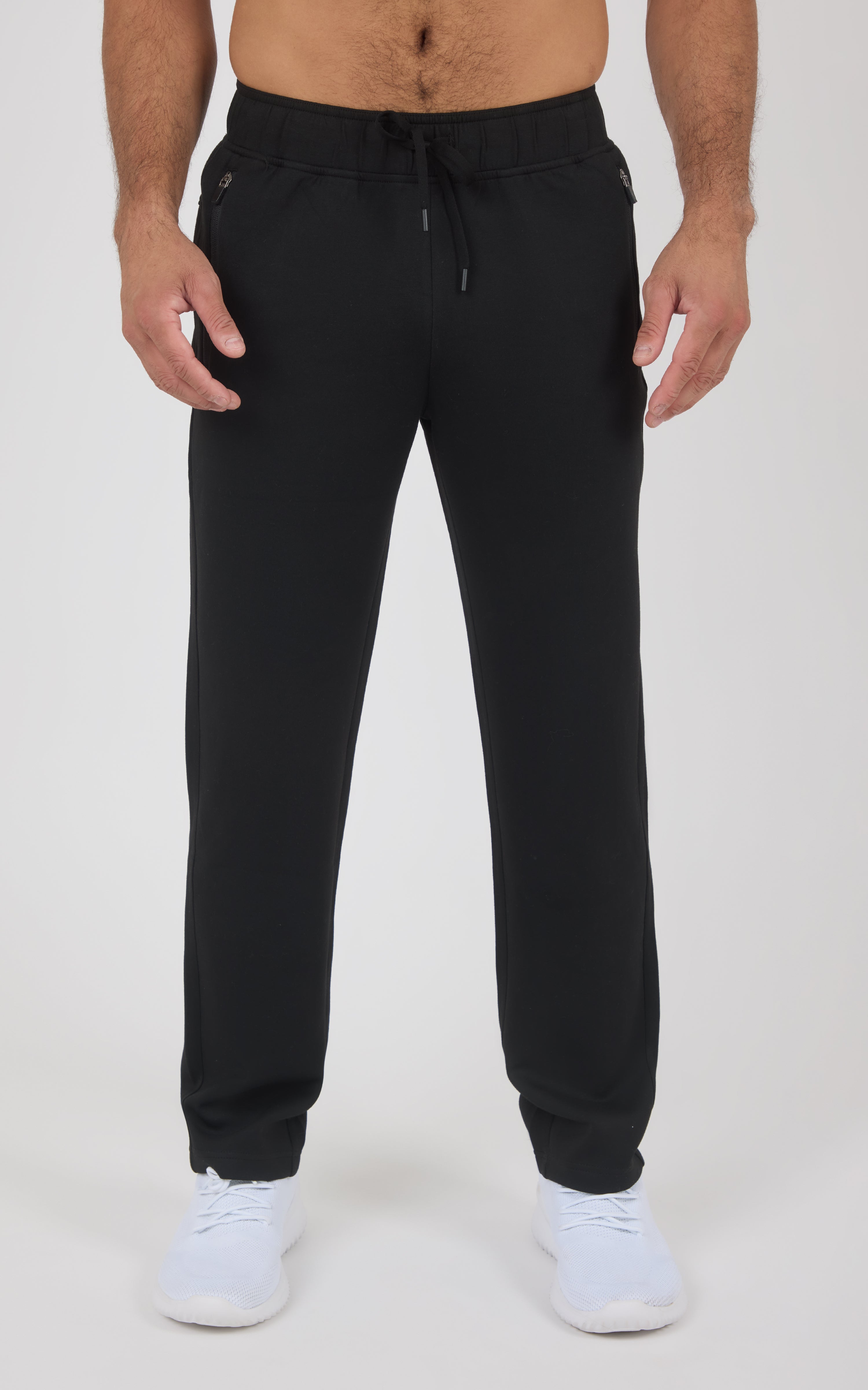 Black straight-leg pants with elastic waistband and drawstring, made from soft lightweight fabric, worn with white sneakers.