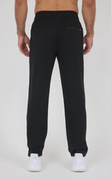 Black straight-leg soft fabric pants with elastic waistband and ankle cuffs, rear zip pocket visible.