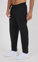 Black men's joggers with a soft, tapered fit, elastic drawstring waist, cuffed ankles, and white sneakers.