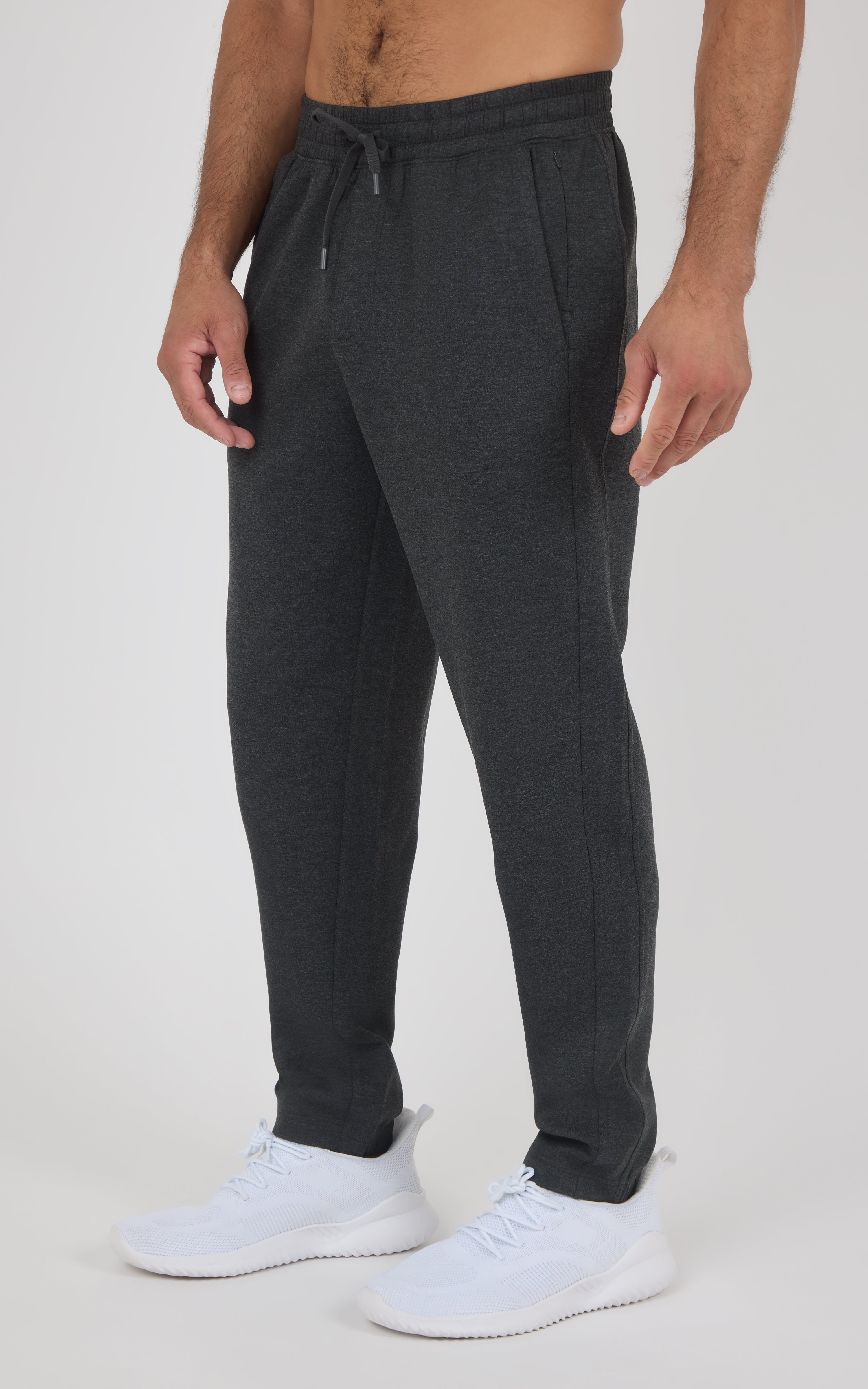 Charcoal gray jogger pants with a drawstring waist, tapered legs, and white sneakers.