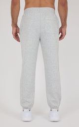 Light gray tapered joggers with an elastic waistband and cuffs, shown from the back with white sneakers.