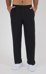Black straight-leg pants with a soft, smooth fabric, elastic waistband, and side pockets worn with white sneakers on a light