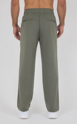 Olive green straight-leg pants with elastic waistband and back welt pockets, relaxed fit on model.