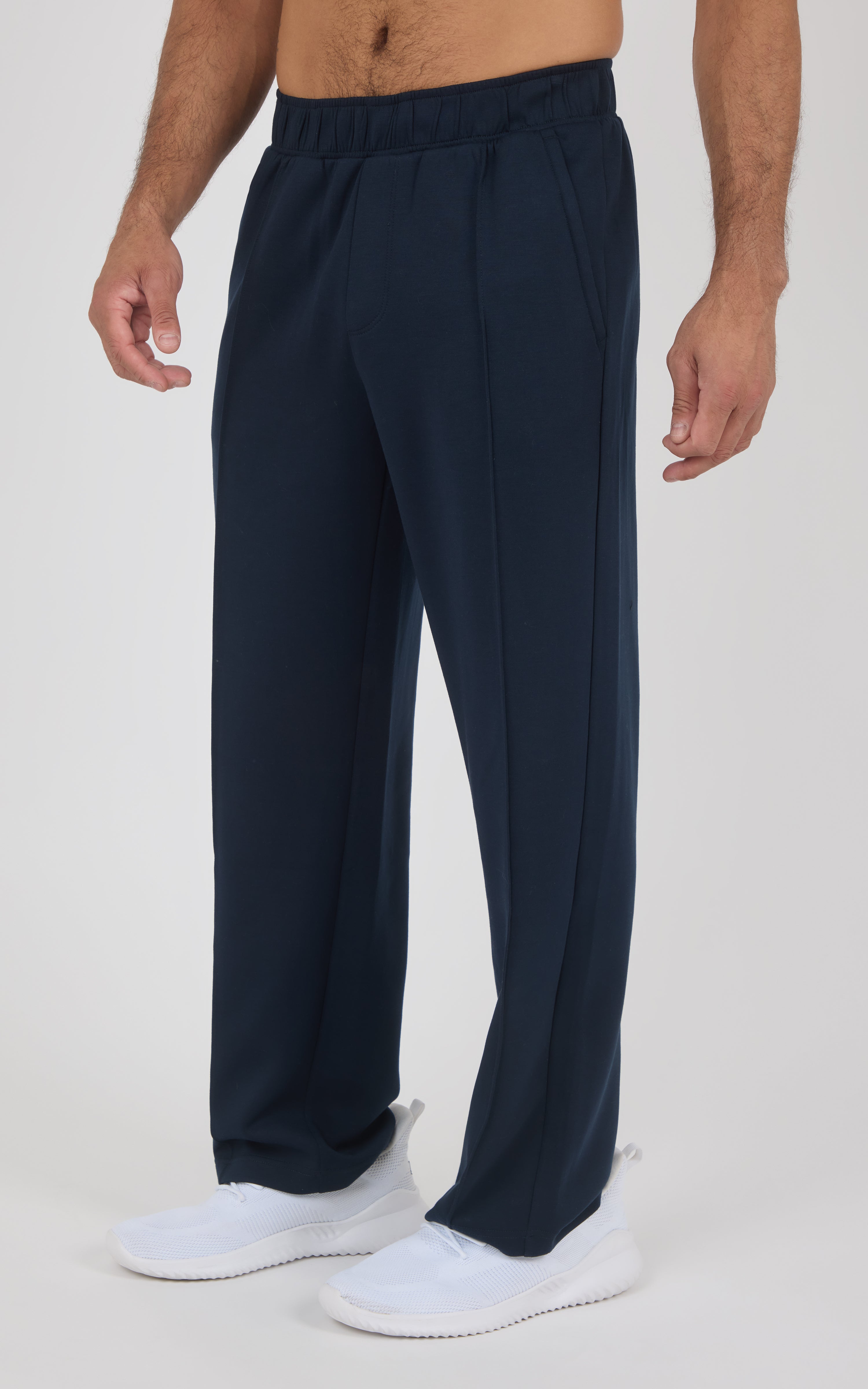 Men’s navy blue straight-leg pants with elastic waistband and side pockets, lightweight fabric, worn with white slip-on.