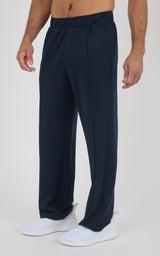 Men’s navy blue straight-leg pants with elastic waistband and side pockets, lightweight fabric, worn with white slip-on.