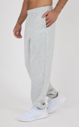 Light gray fleece joggers with a relaxed fit, elastic waistband, side pockets, and cuffed ankles worn with white sneakers.