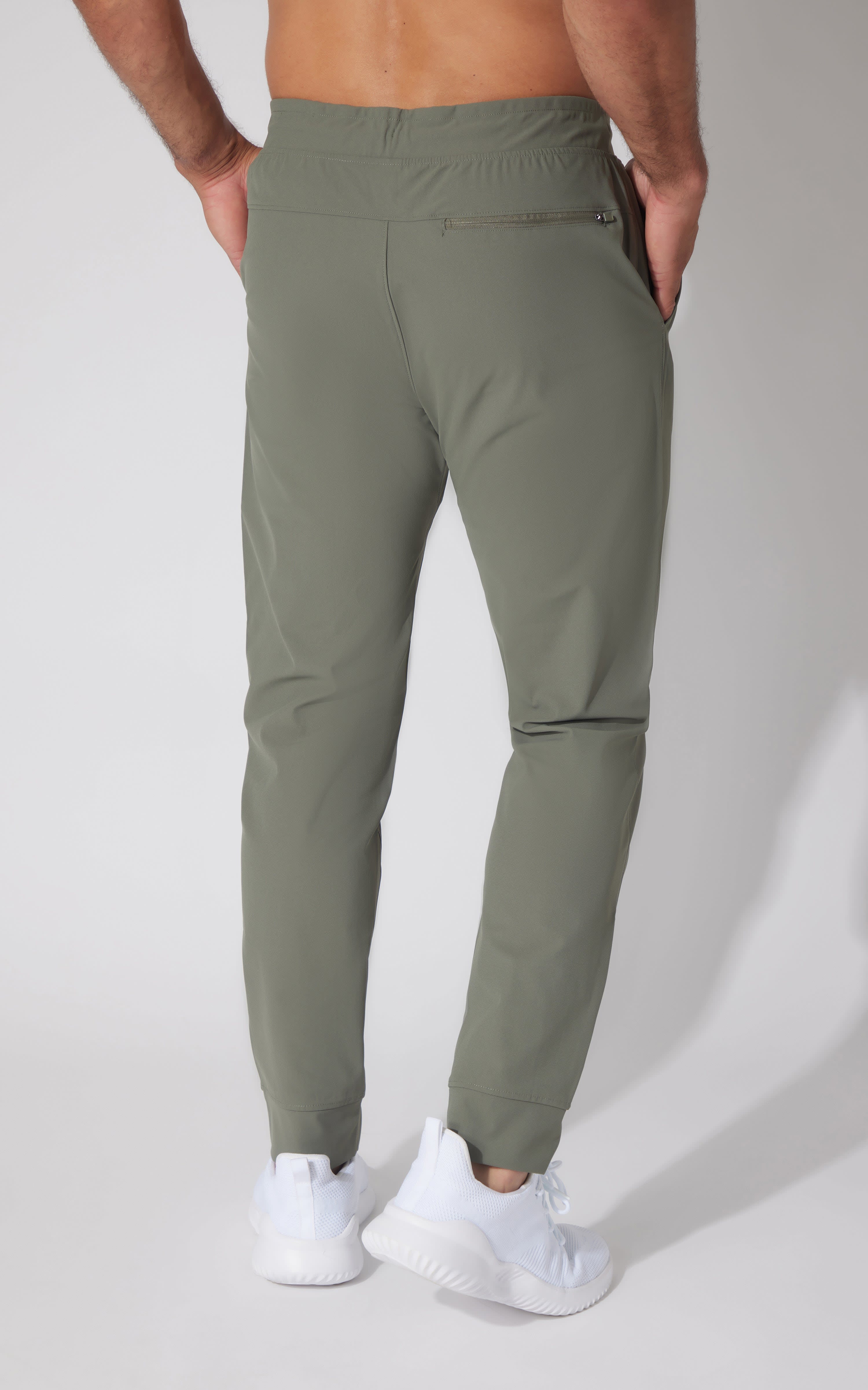 Men's slim-fit joggers in muted green with elastic waistband and cuffed ankles.