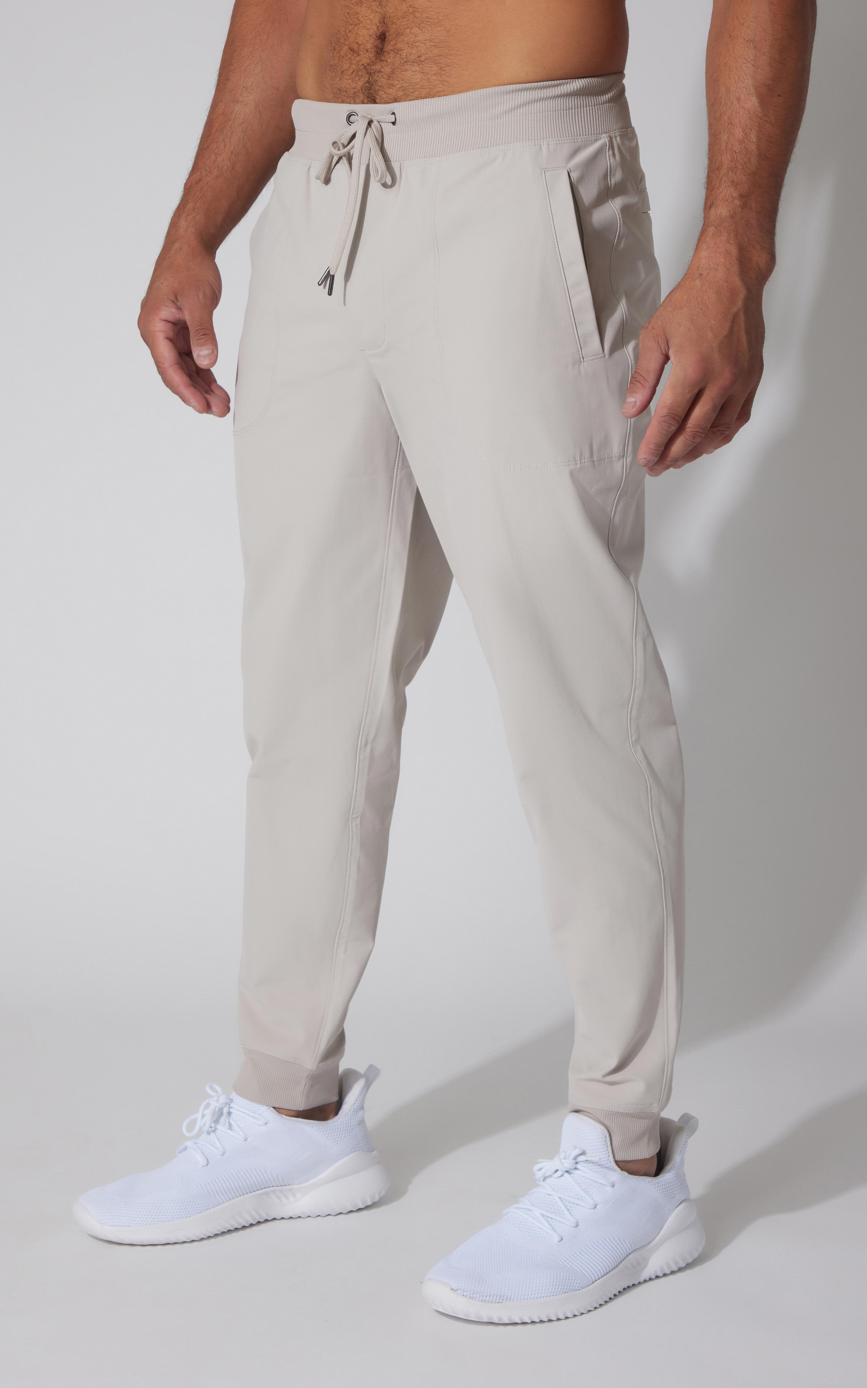 Men's light beige tricot joggers with drawstring waist and tapered legs.