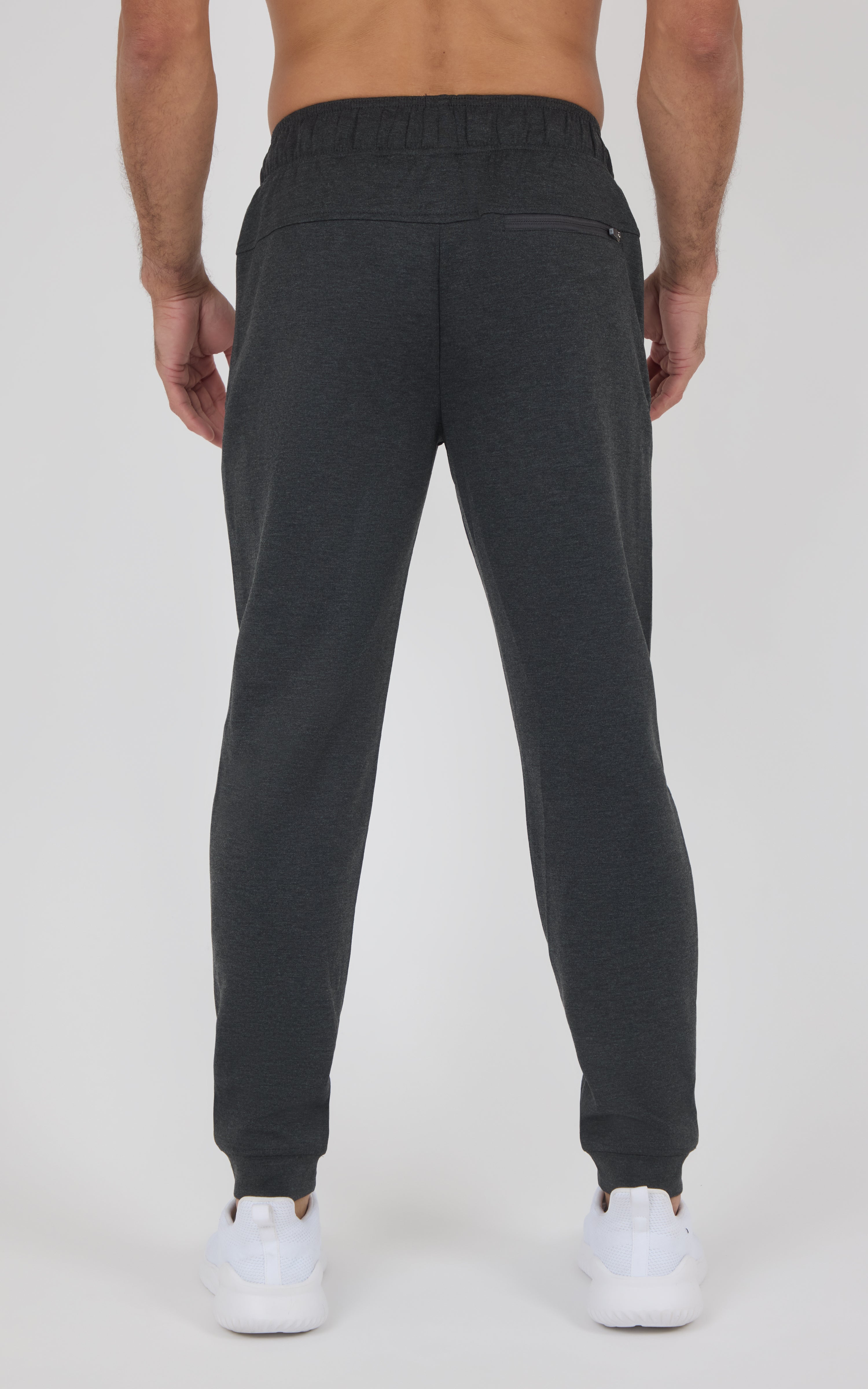 Black soft-knit jogger pants with a tapered fit, elastic cuffs, and back pockets, shown from behind.