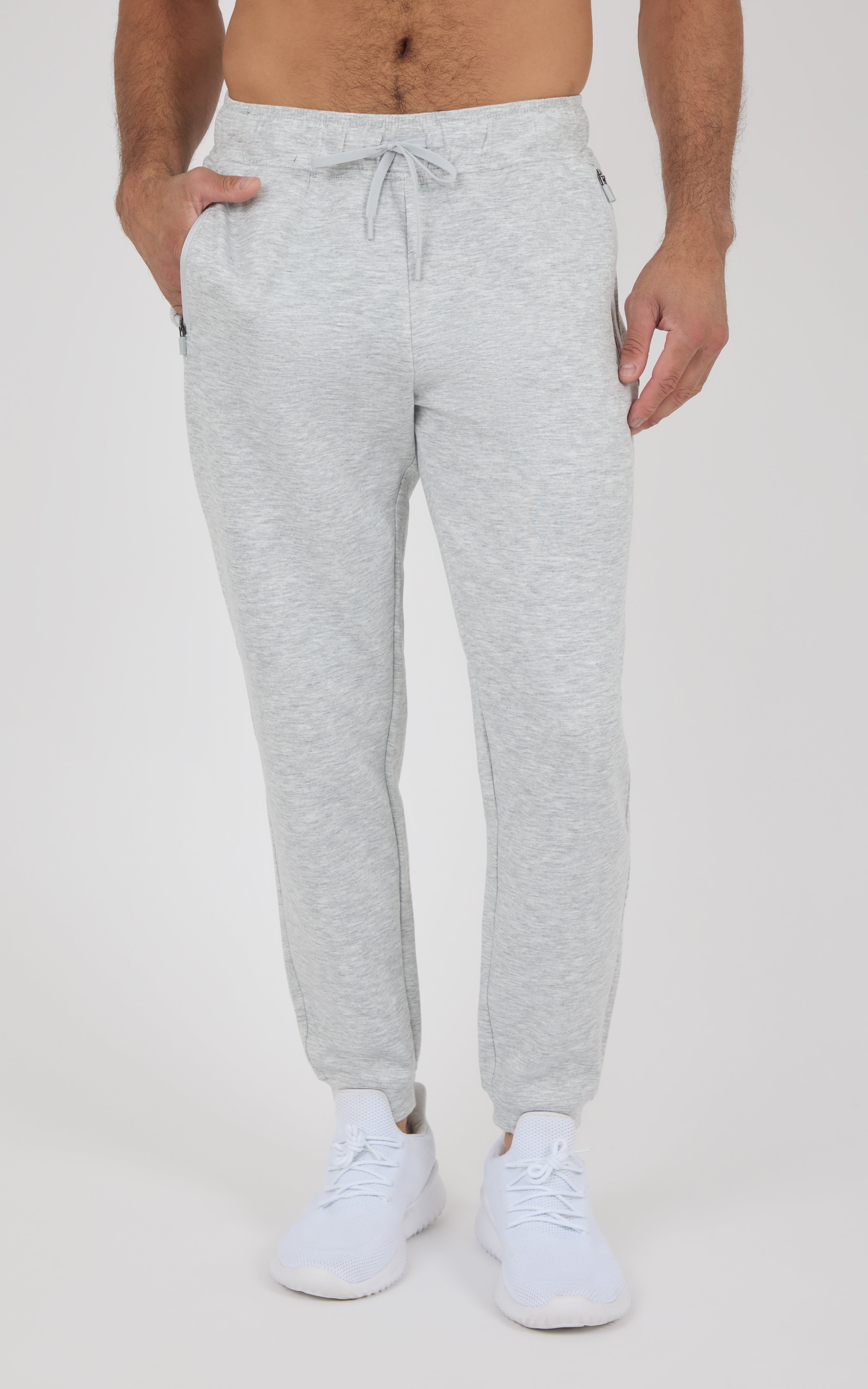 Light gray marl men’s joggers with a drawstring waist, side pockets, tapered legs, and elastic cuffs, styled with white.