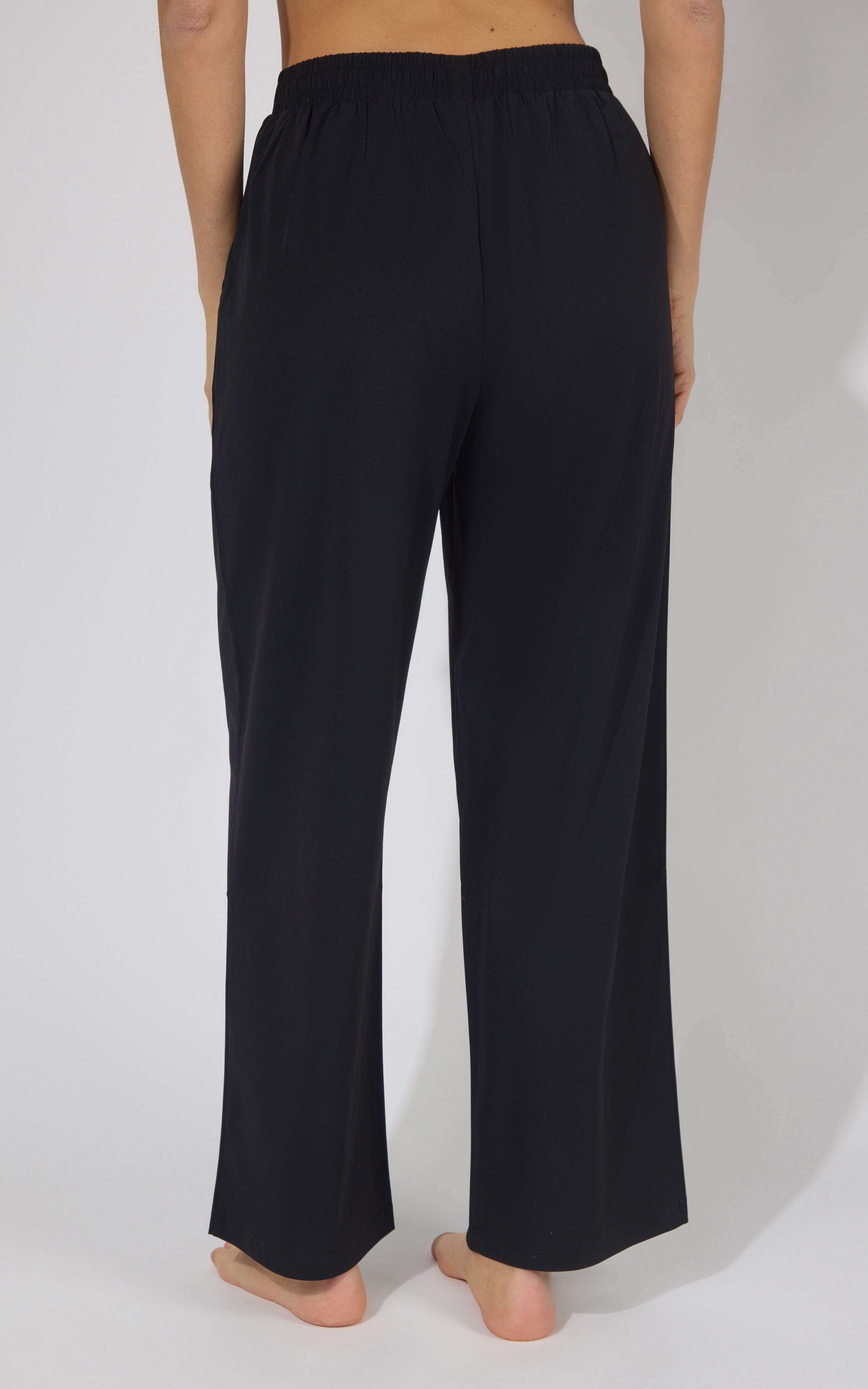Black wide-leg pleated trouser pants with a straight cut and elastic waistband.