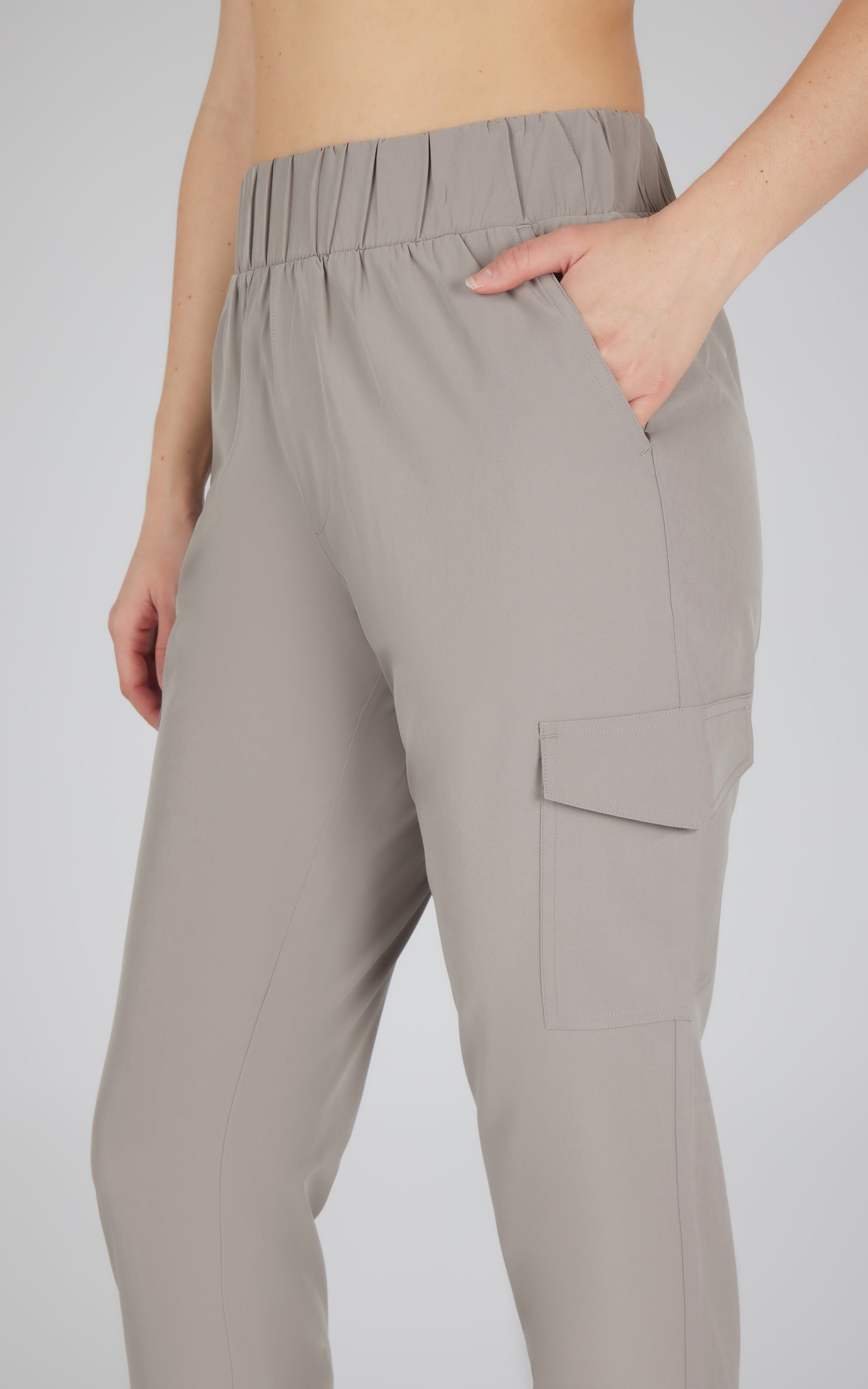 Light gray cargo joggers with elastic waistband and side flap pocket worn by model.