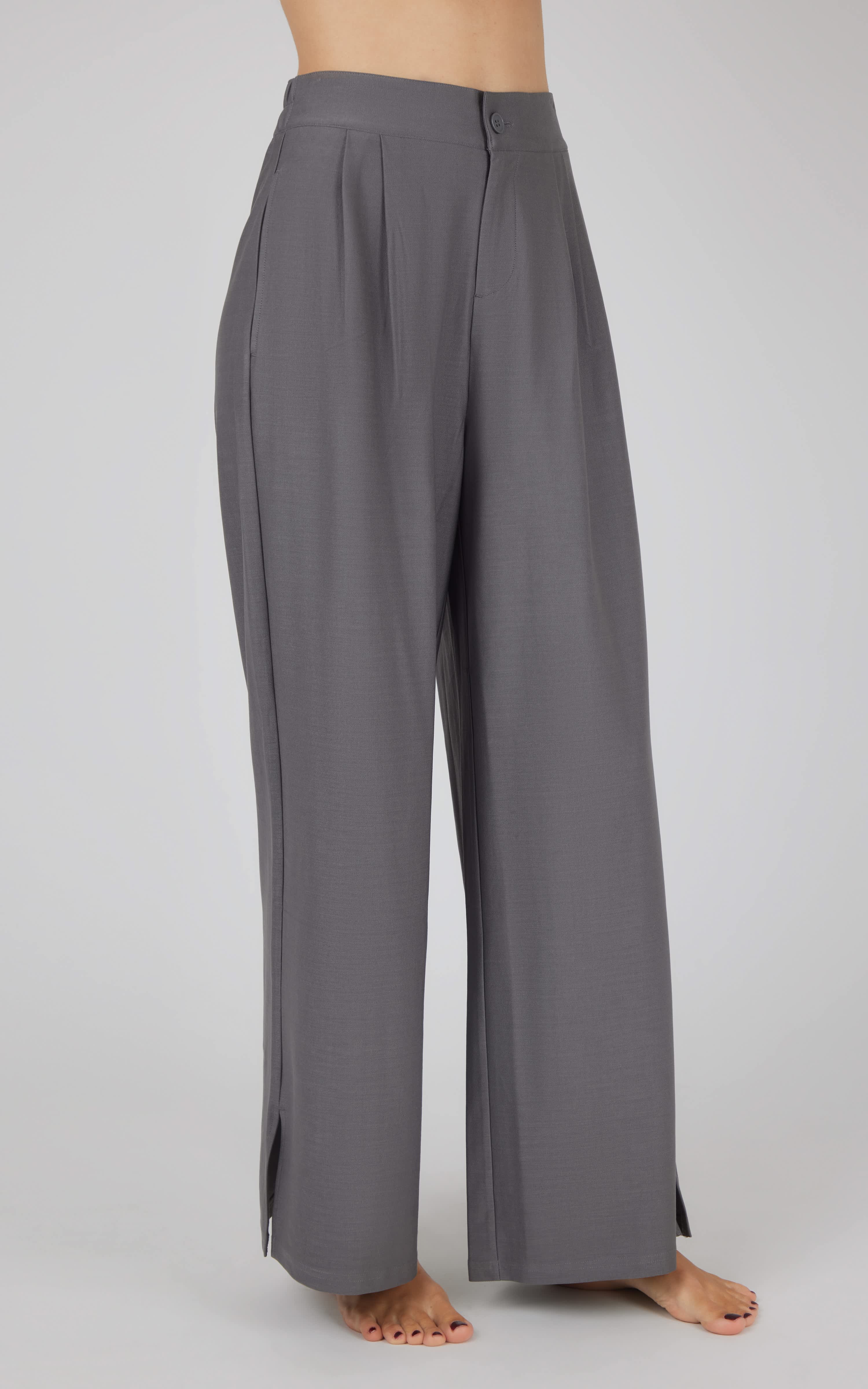 Charcoal wide-leg trousers with pleated front and high waist, worn barefoot.