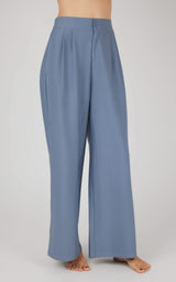 Light blue wide-leg pleated trousers for women, high-waisted with relaxed fit.