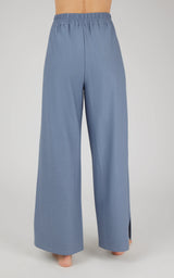 Women's wide leg pants in muted blue with elastic waistband and small side slits at hem.