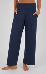 Navy blue pleated wide-leg trousers with a relaxed fit, front pockets, and a clean straight hem.
