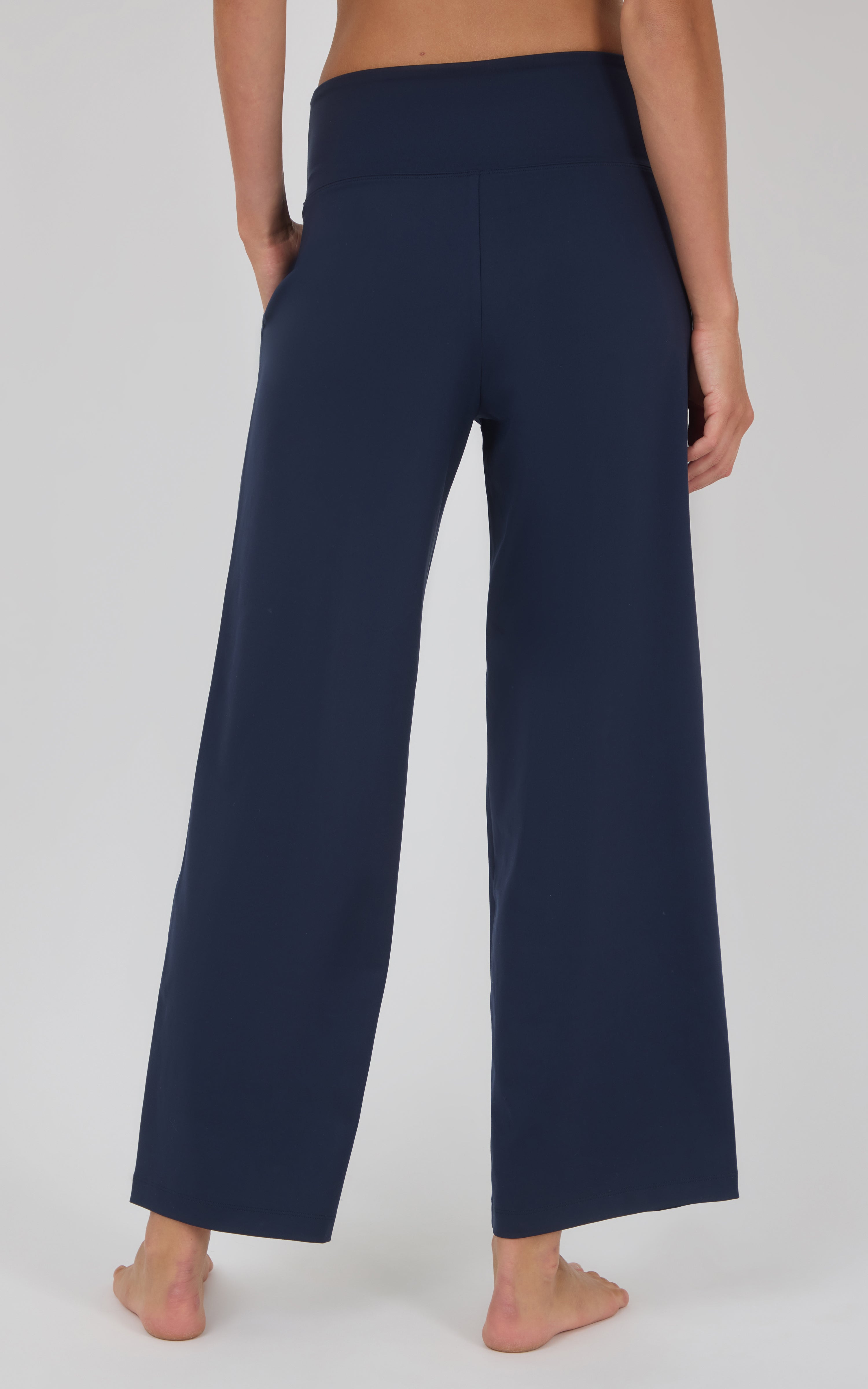 Navy blue high-waisted wide-leg trousers with a smooth finish and loose, straight-cut legs.