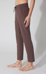 Straight leg chocolate brown pants with a drawstring waist and side pockets, worn barefoot.