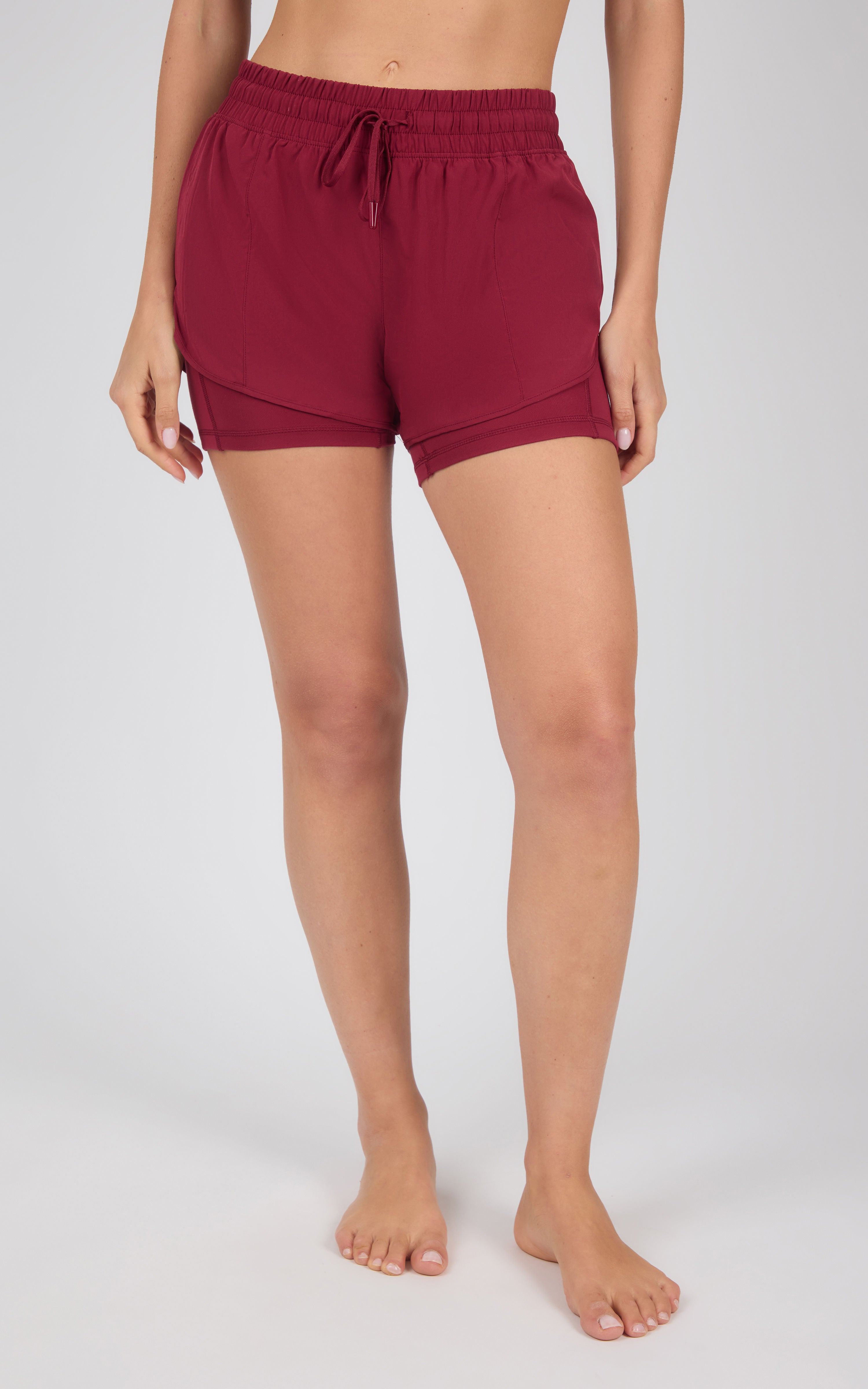 Women’s lightweight maroon running shorts with adjustable drawstring waist and relaxed fit.