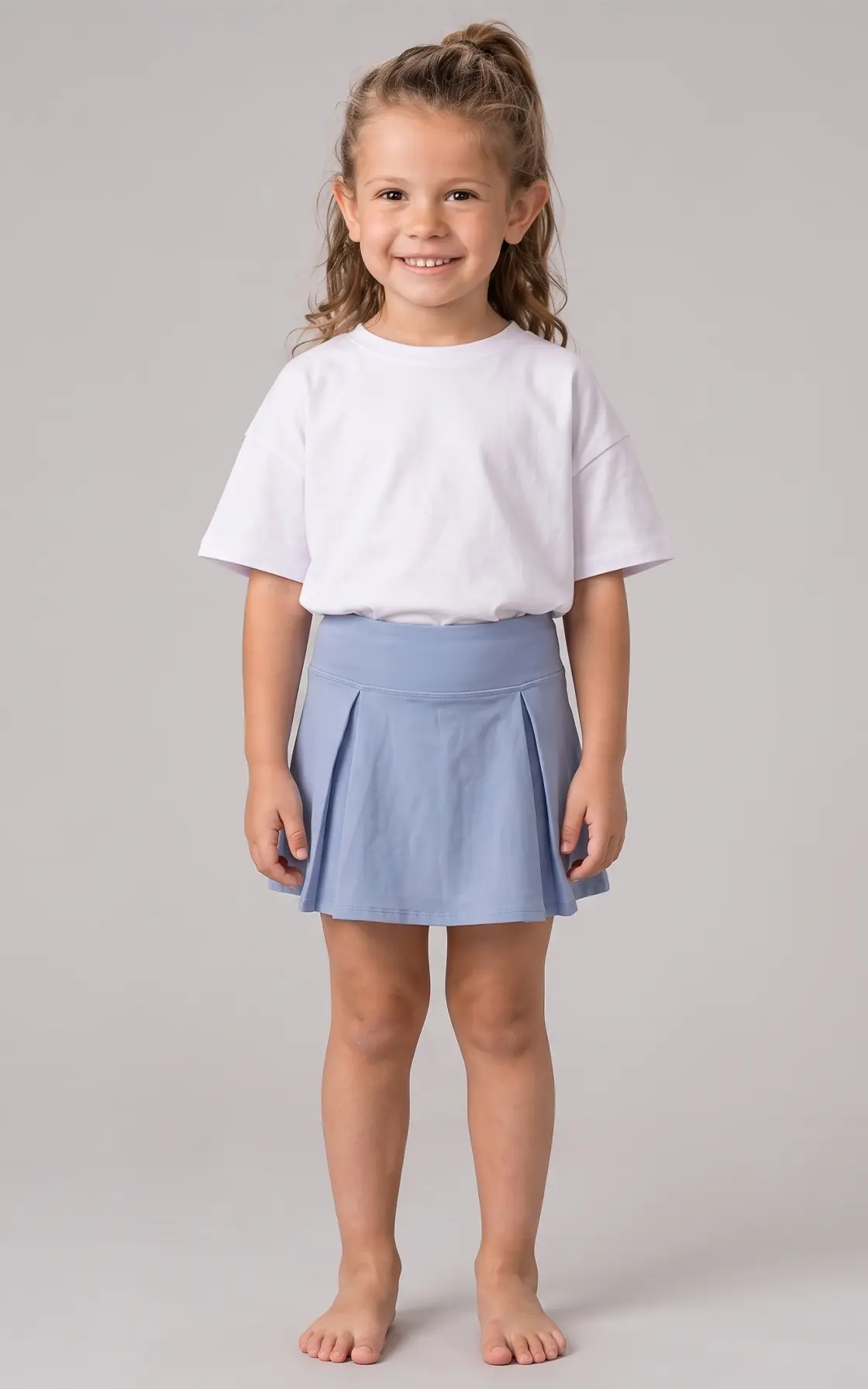 Light blue girls pleated skort paired with a plain white short-sleeve t-shirt.