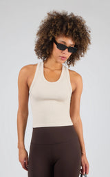 Off-white ribbed racerback tank top with a fitted silhouette and scoop neckline.
