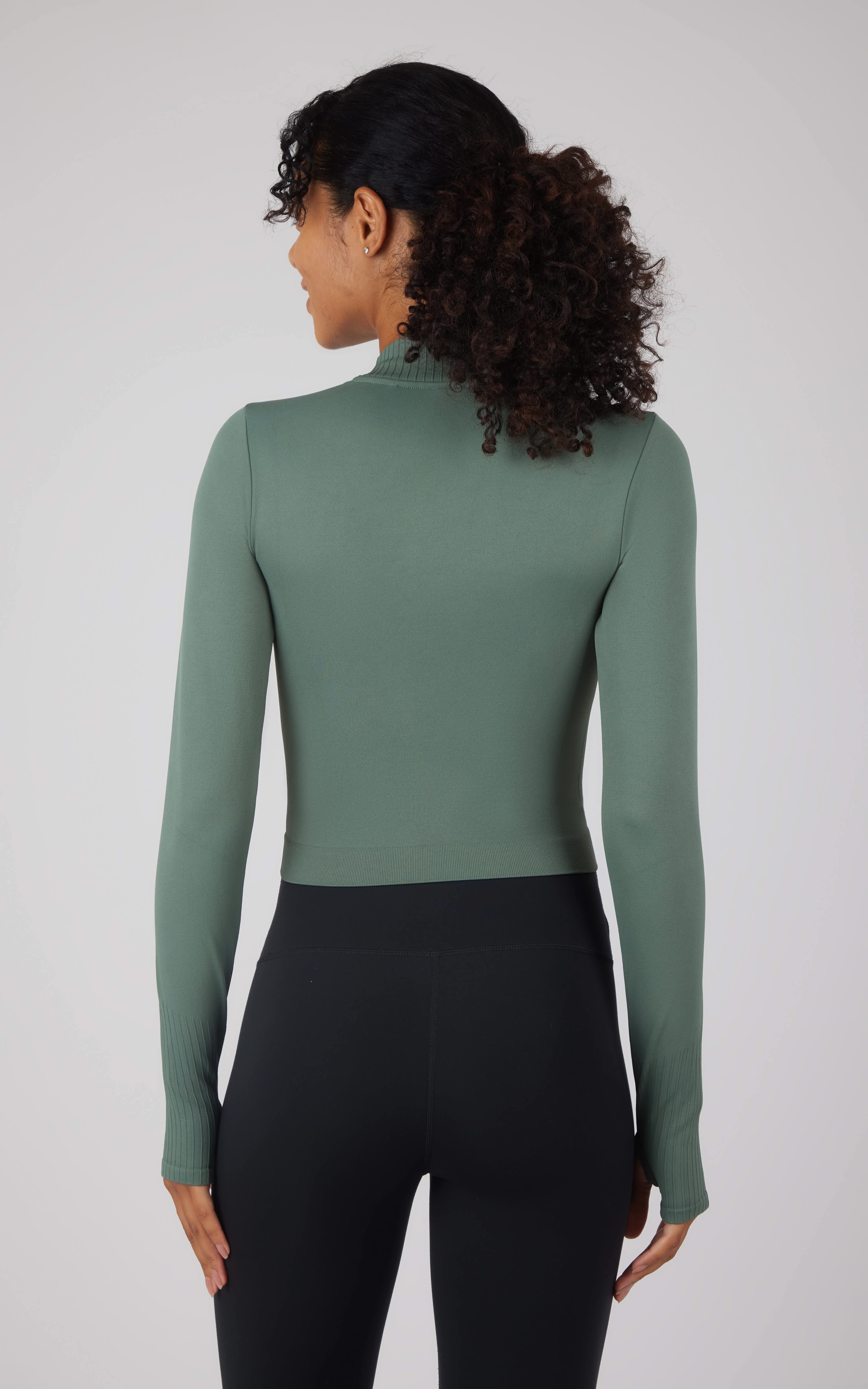 Seamless long sleeve top in dark forest green with fitted silhouette and mock neck.