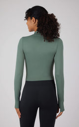 Seamless long sleeve top in dark forest green with fitted silhouette and mock neck.