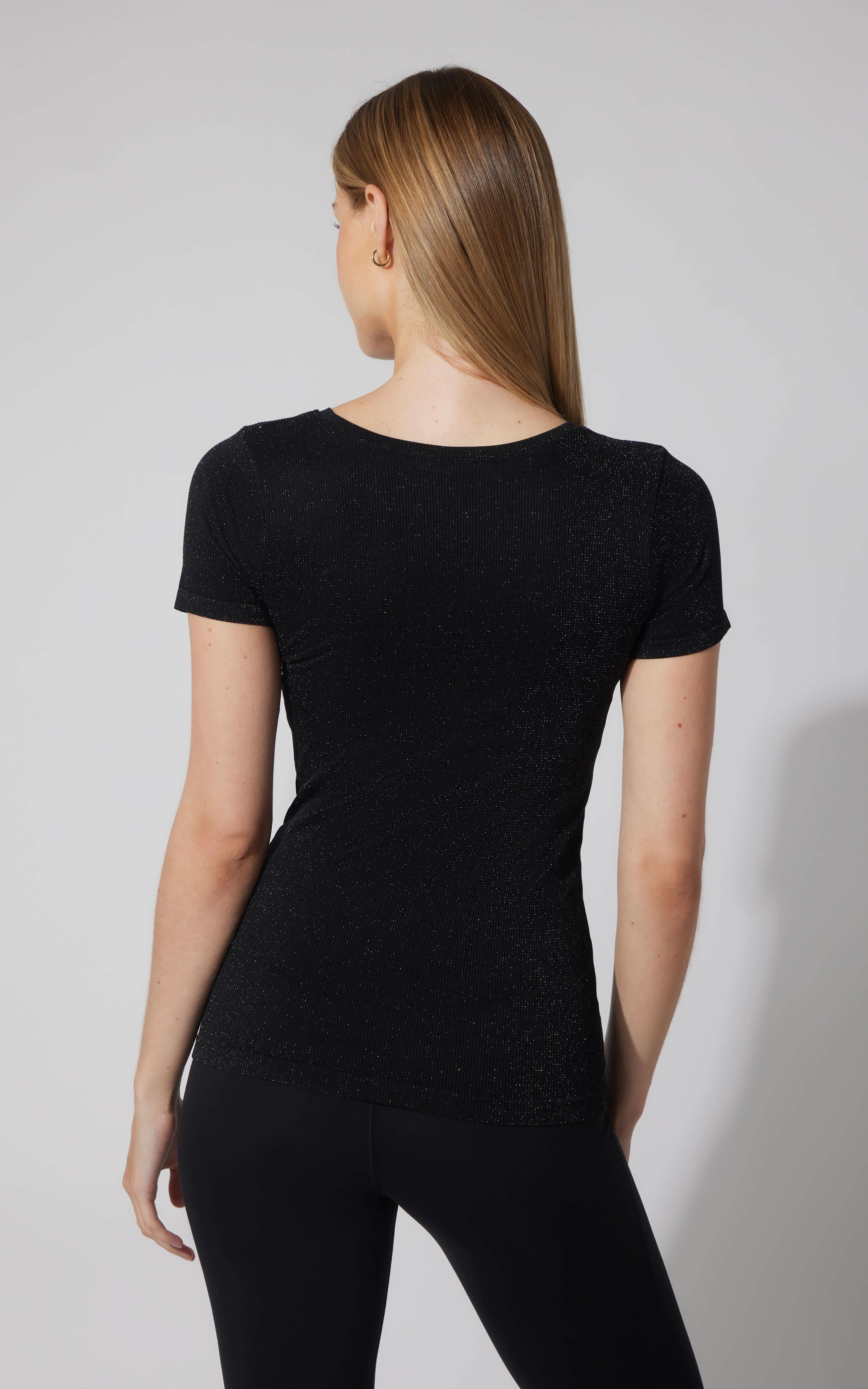 Black seamless short sleeve active shirt with fitted silhouette on female model, back view.