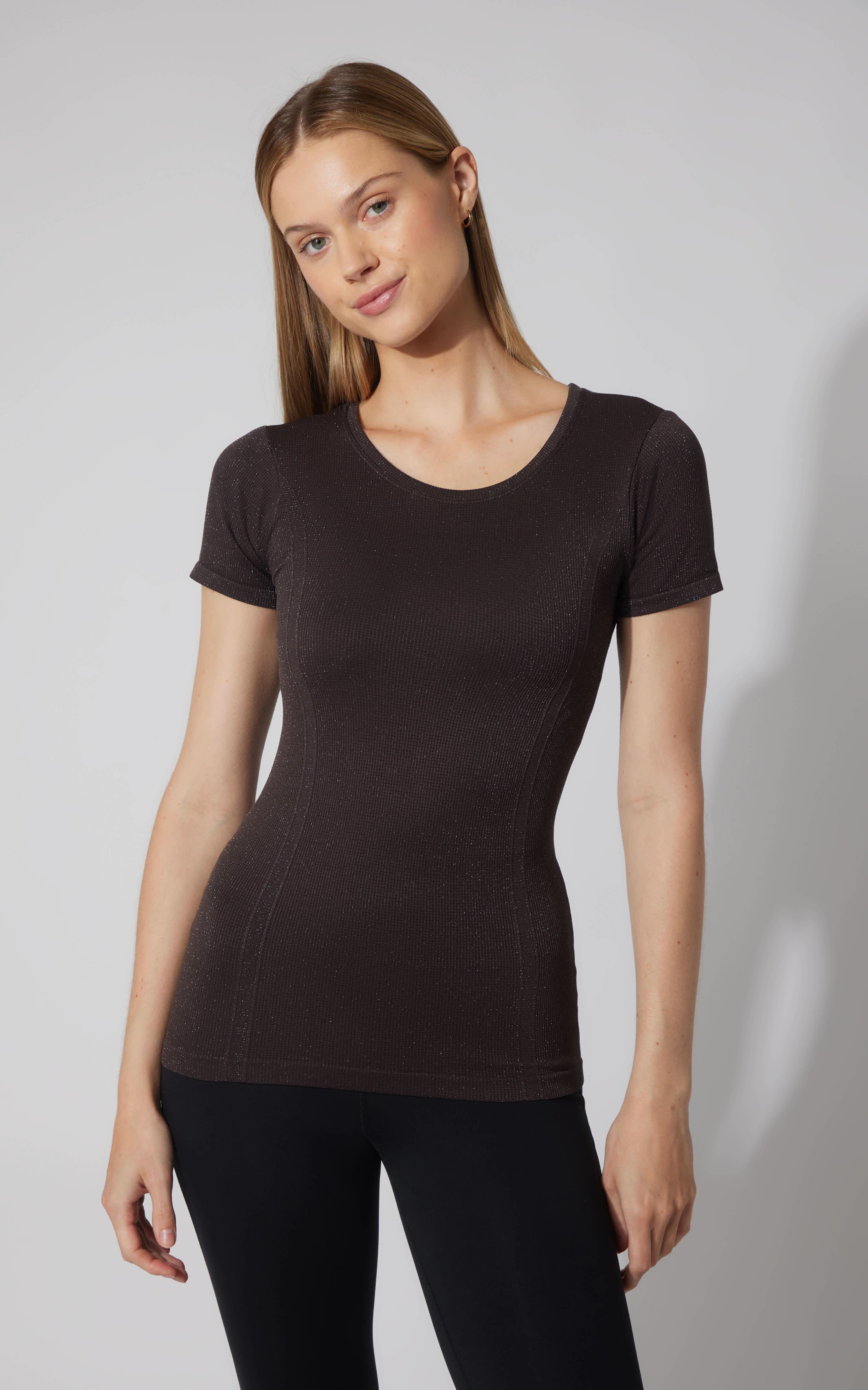 Black seamless short sleeve active shirt with crew neck, fitted silhouette on model.