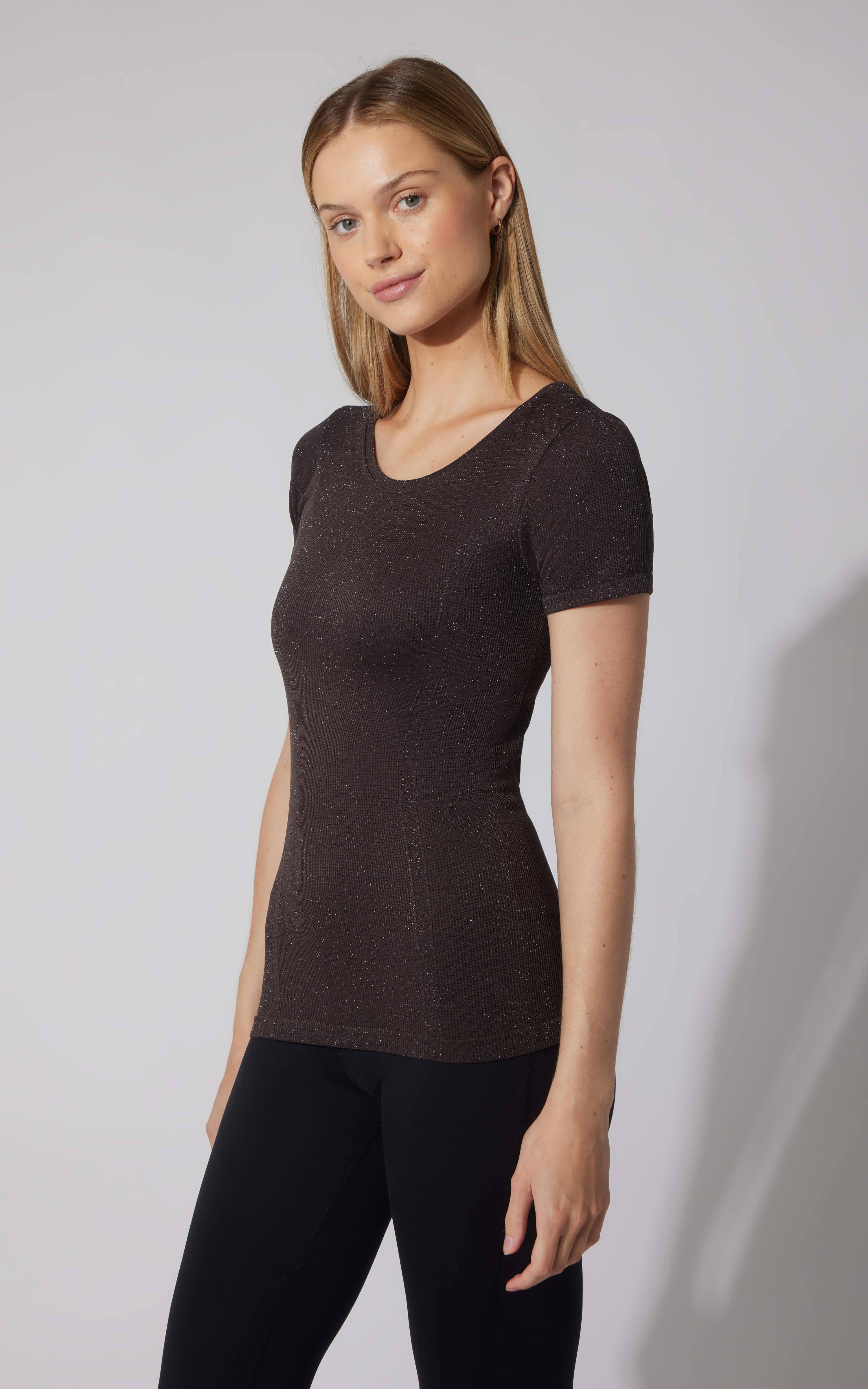Black seamless short sleeve active shirt with crew neckline on female model.