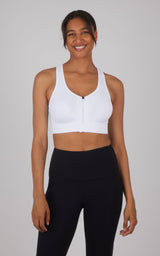 White full zip seamless bra with racerback and black high-waist leggings on smiling woman.