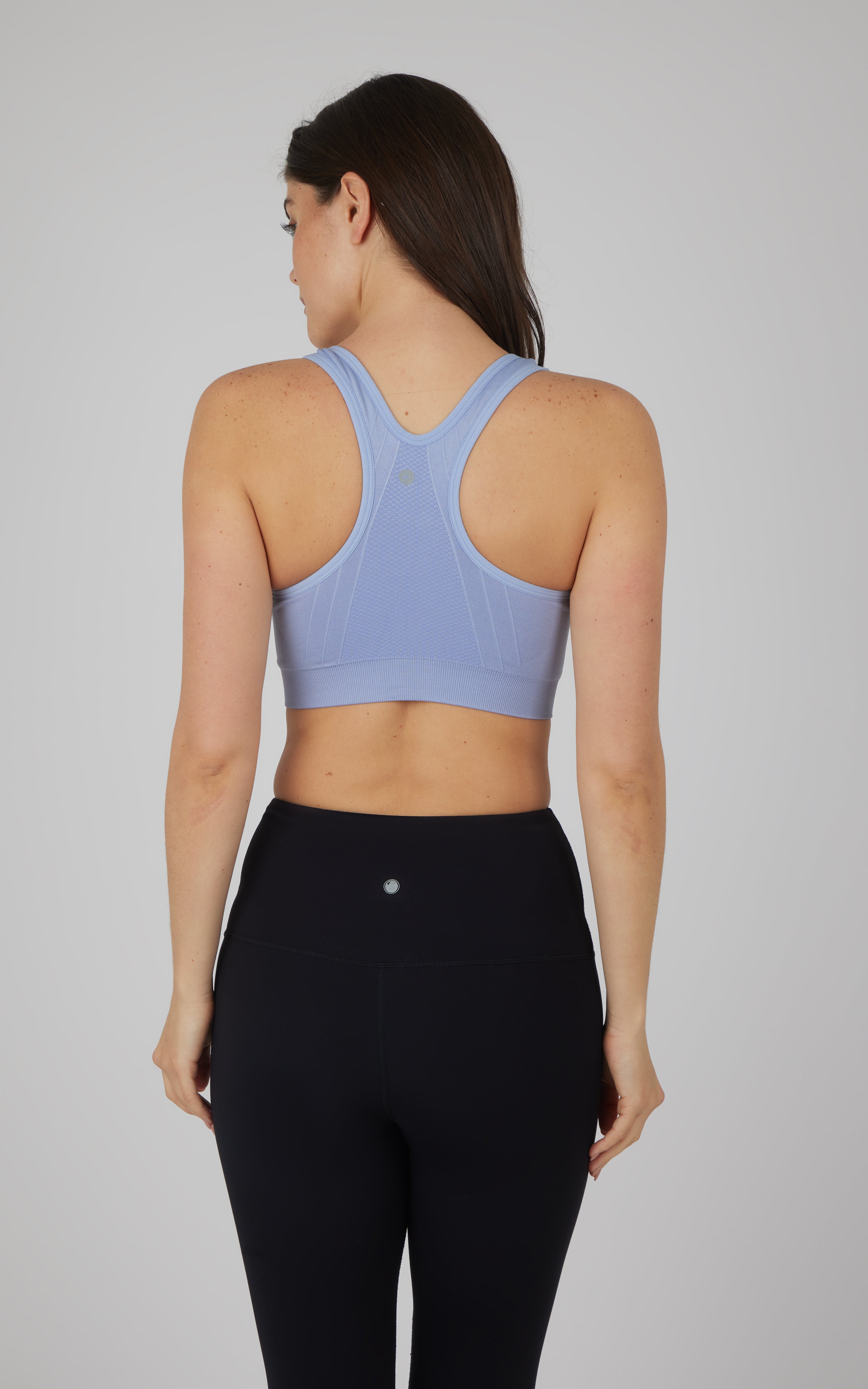 Light blue seamless full-zip sports bra with racerback design and smooth fabric.