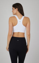 White seamless full-zip sports bra with racerback design and smooth fabric finish.