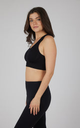 Black seamless full-zip bra with wide straps and smooth fabric on a woman.