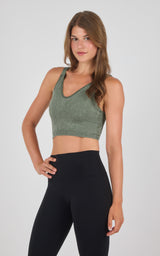 Olive green seamless ribbed bra tank with wider straps and V-neck, paired with high-waisted black leggings.