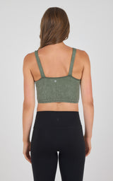 Seamless ribbed tank bra in muted green stone wash with adjustable straps and cropped fit.