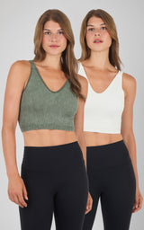 Two women wearing seamless ribbed bra tanks, one in olive green and one in off-white, paired with black leggings.