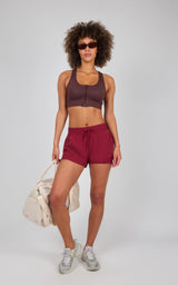 Seamless textured zip bra top in deep brown with scoop neckline and racerback, paired with high-rise burgundy athletic.