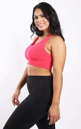 Plus seamless racerback bra in Calypso Red on plus-size model with black leggings.
