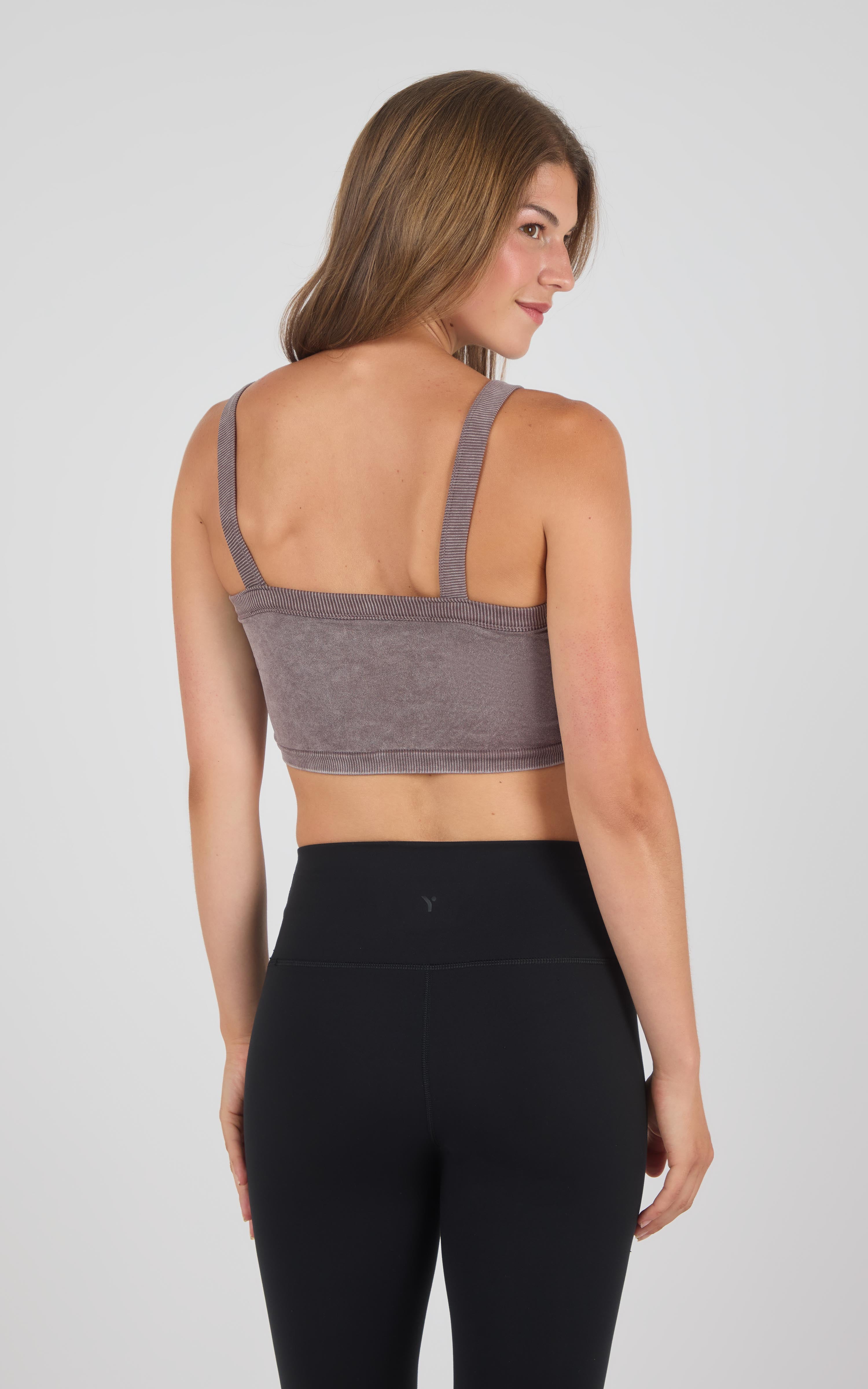 Mauve seamless bra tank with wide straps on woman wearing black leggings, back view.